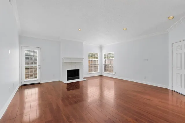 a view of a room with wooden floor fireplace and window