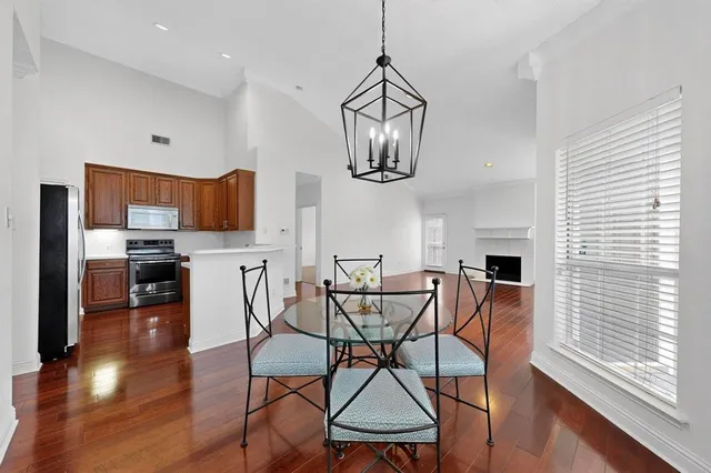 a view of a dining room with furniture a kitchen and chandelier
