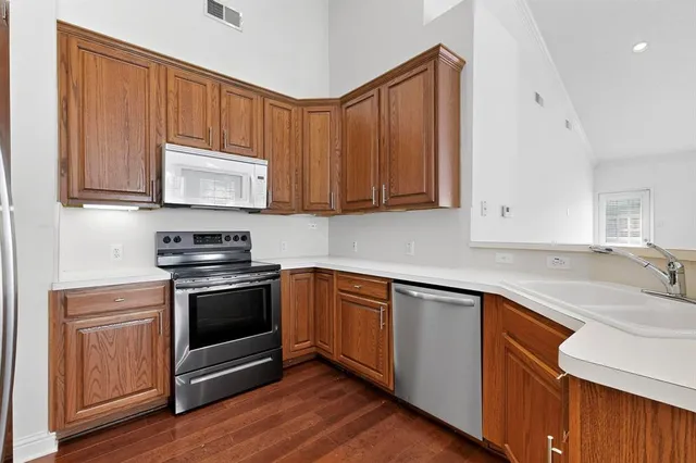 a kitchen with stainless steel appliances granite countertop a stove a sink and a microwave