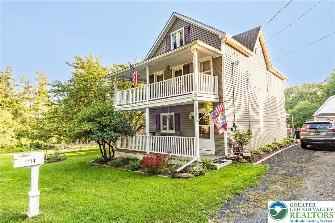 1114 Fox Gap Road Bangor, PA 18013 - Photo 46 of 63 A charming two-story home features dual covered porches overlooking a spacious grassy lawn.