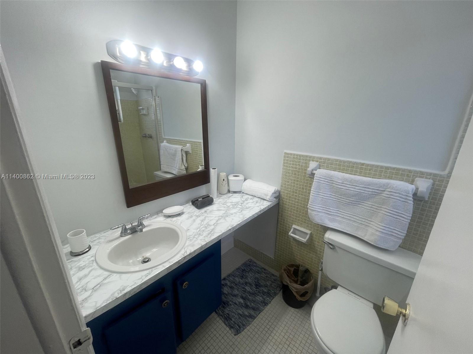 1420 Atlantic Shores Boulevard, Unit 326 Hallandale Beach, FL 33009 - Photo 12 of 16 a bathroom with a granite countertop toilet sink and mirror