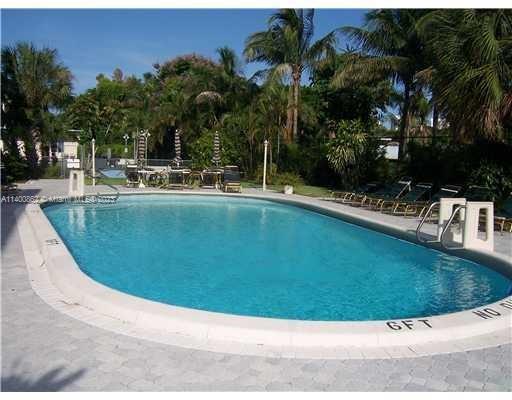 1420 Atlantic Shores Boulevard, Unit 326 Hallandale Beach, FL 33009 - Photo 3 of 16 a view of a swimming pool with a garden