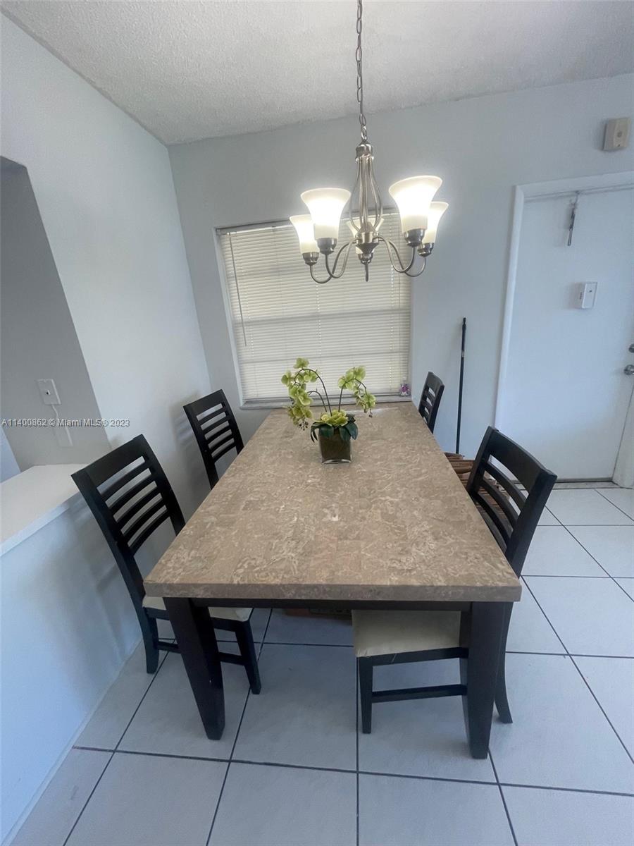 1420 Atlantic Shores Boulevard, Unit 326 Hallandale Beach, FL 33009 - Photo 6 of 16 a view of a dining room with furniture and chandelier