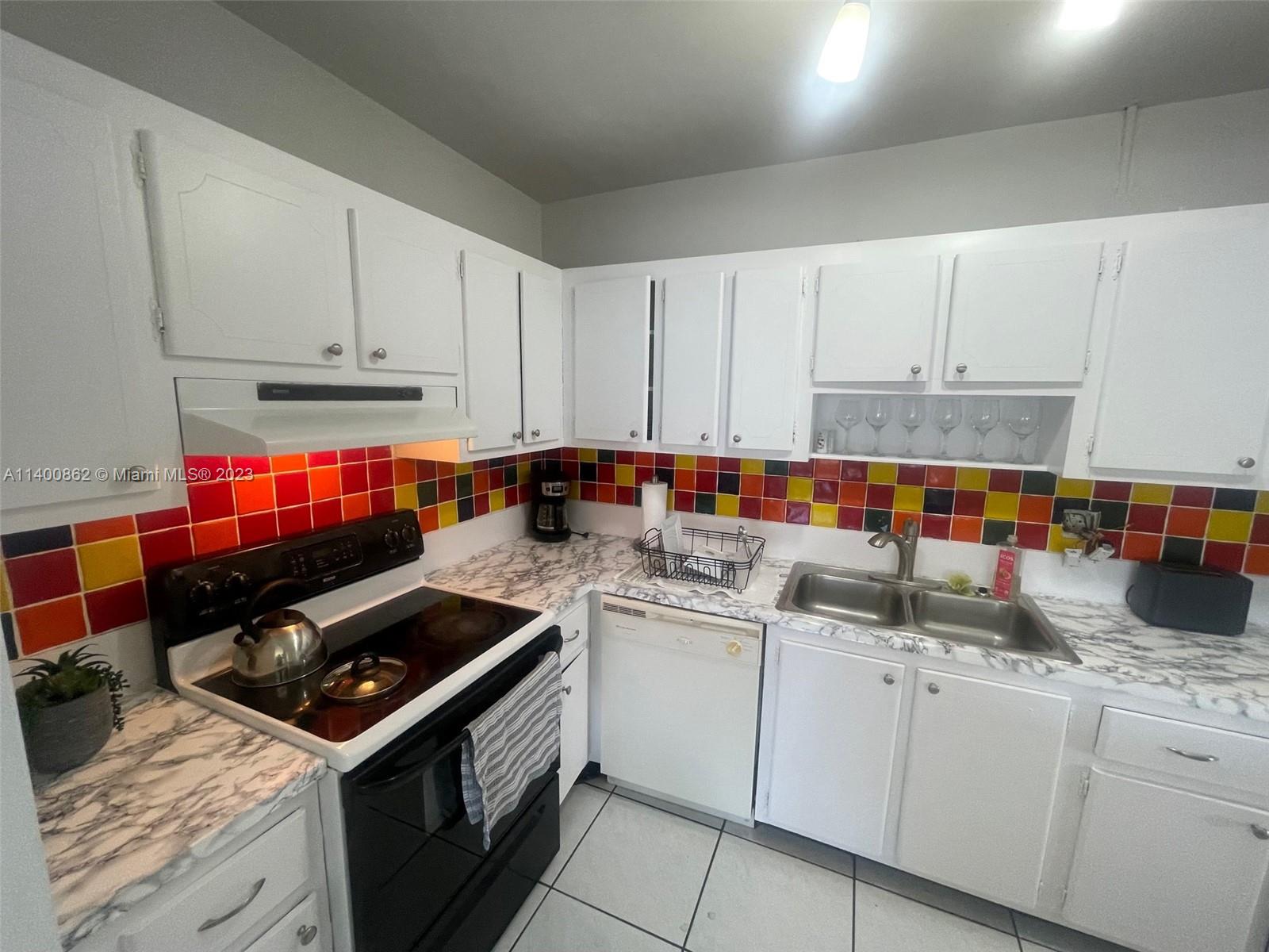 1420 Atlantic Shores Boulevard, Unit 326 Hallandale Beach, FL 33009 - Photo 7 of 16 a kitchen with stainless steel appliances granite countertop a stove sink and cabinets