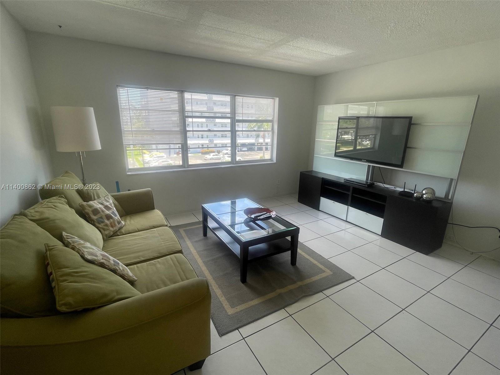 1420 Atlantic Shores Boulevard, Unit 326 Hallandale Beach, FL 33009 - Photo 9 of 16 a living room with furniture and a window