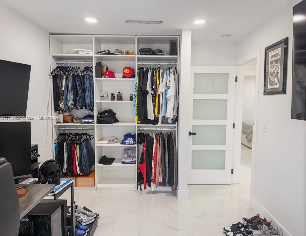 9101 Southwest 11th Street Miami, FL 33174 - Photo 16 of 25 a view of walk in closet with clothes and shoes