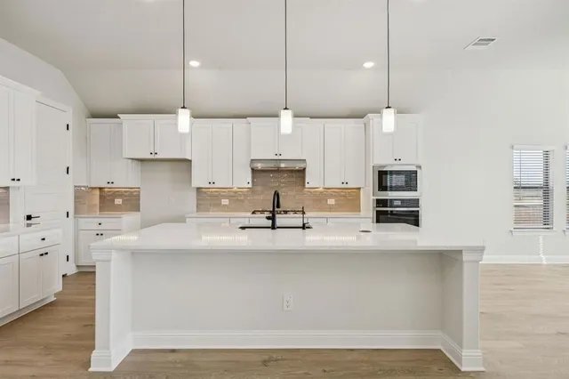 a large kitchen with stainless steel appliances kitchen island a large counter space a sink and a cabinets