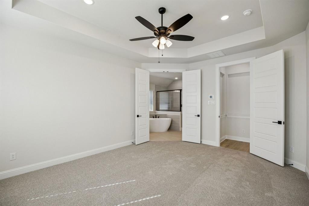 744 Carriage Hl Road Midlothian, TX 76065 - Photo 8 of 23 an empty room and a bathroom with a ceiling fan