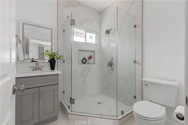 a bathroom with a shower sink mirror and toilet