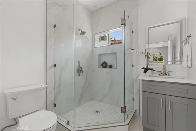 a bathroom with a shower a toilet and sink