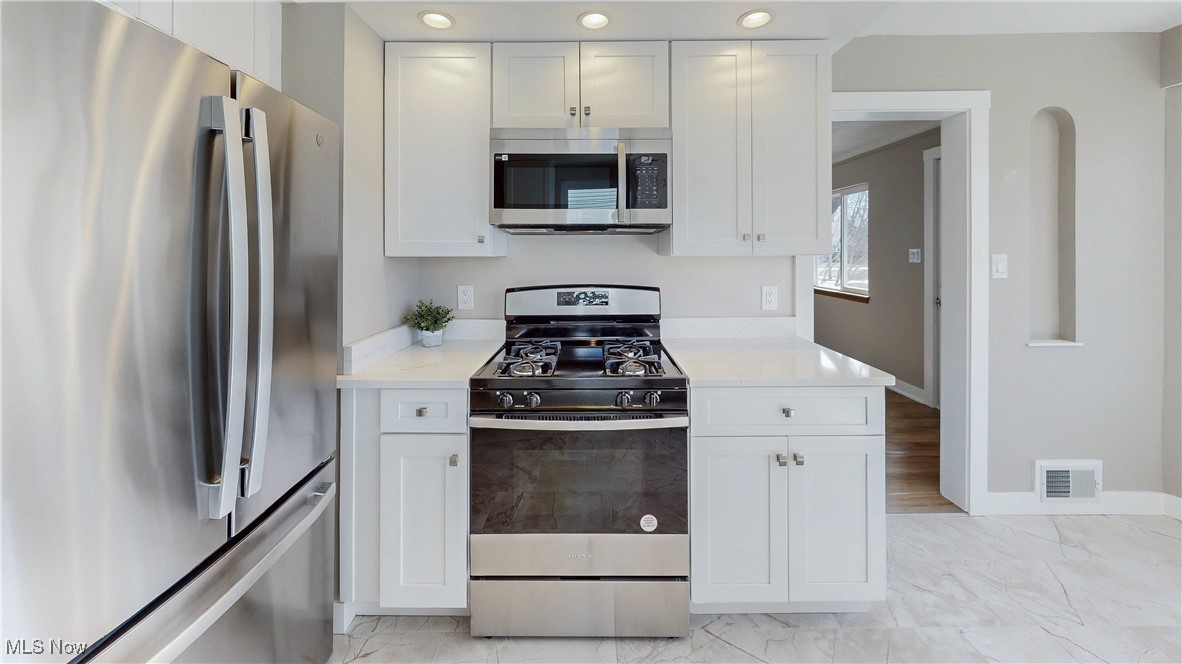 3318 Hearthstone Road Cleveland, OH 44134 - Photo 10 of 35 Main kitchen with white cabinetry, light countertops, appliances with stainless steel finishes, and a sink