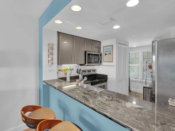 a kitchen with stainless steel appliances granite countertop a sink and a granite counter tops
