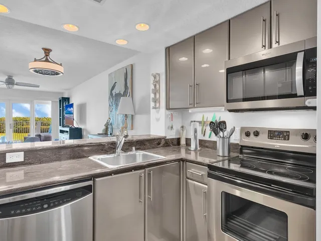 a kitchen with stainless steel appliances a stove microwave and sink