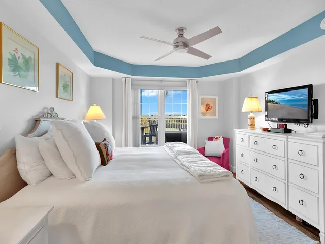 a bedroom with a bed a window and a flat screen television