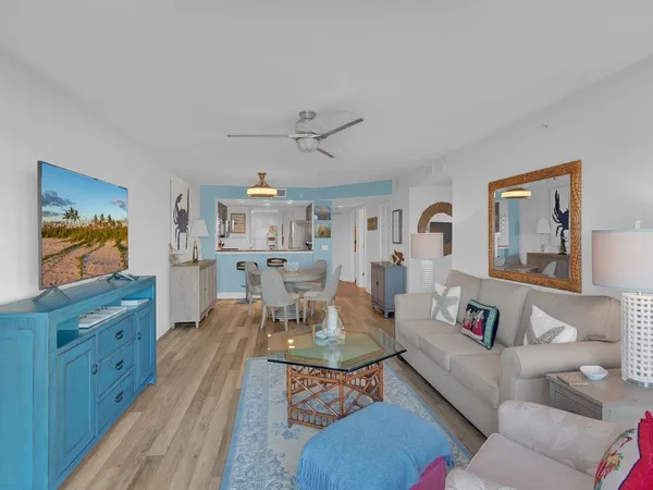 a living room with furniture kitchen view and a window