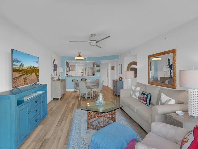 a living room with furniture kitchen view and a window