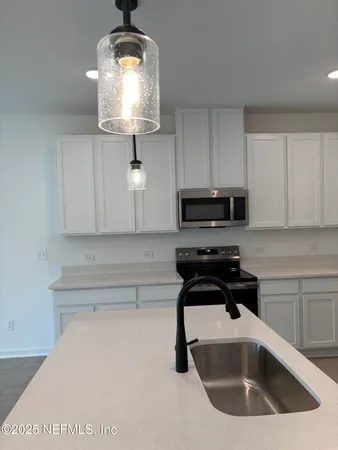 a kitchen with granite countertop a sink a stove and cabinets