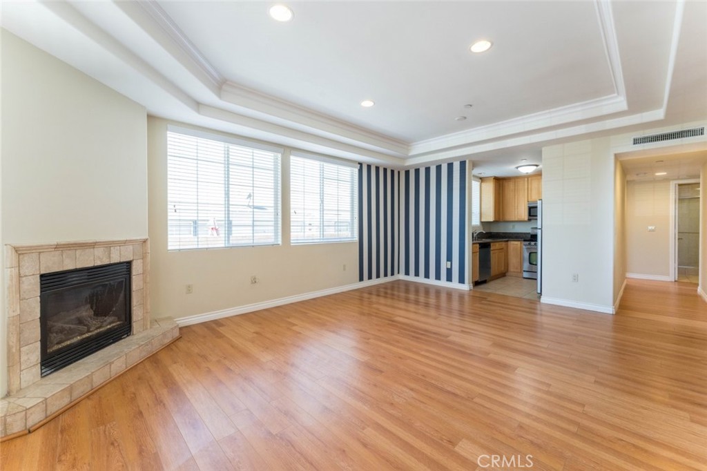 511 East Harvard Road, Unit 101 Burbank, CA 91501 - Photo 4 of 29 an empty room with wooden floor fireplace and windows