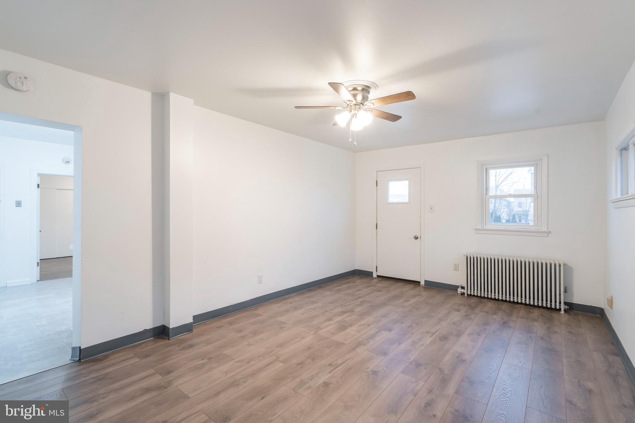 420 Prospect Avenue, Unit 1 Bridgeport, PA 19405 - Photo 5 of 24 an empty room with wooden floor ceiling fan and windows