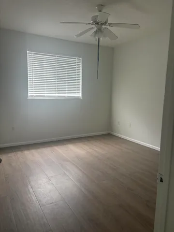 an empty room with windows and fan