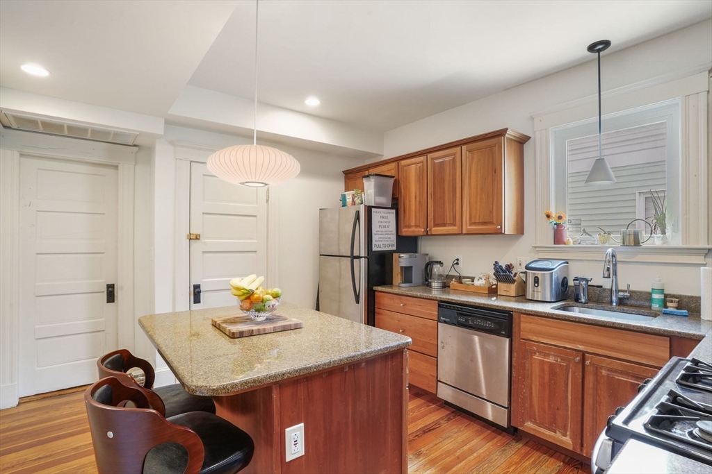 37 Dimick Street, Unit 3 Somerville, MA 02143 - Photo 6 of 12 a kitchen with granite countertop a sink stove and cabinets