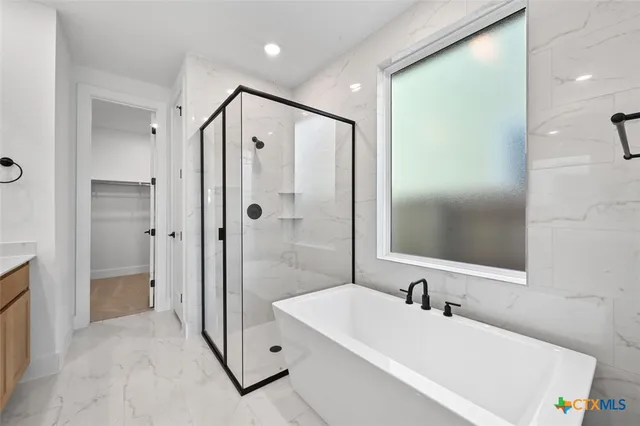 a bathroom with a tub sink shower and mirror