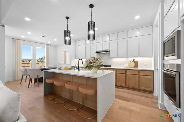 a kitchen with stainless steel appliances granite countertop a sink a stove and a refrigerator