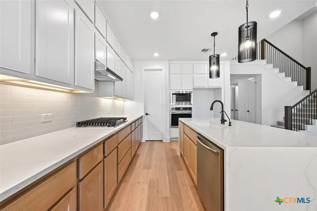 a kitchen with a sink a stove and cabinets
