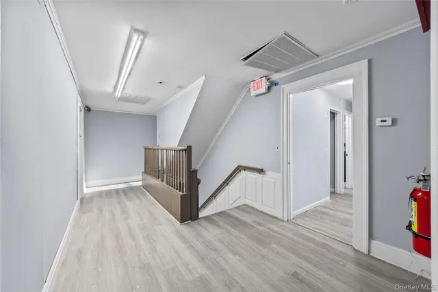 a view of a hallway with wooden floor and stairs