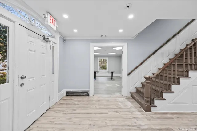 a view of entryway and hall with wooden floor