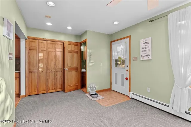 a kitchen with stainless steel appliances granite countertop a refrigerator a sink dishwasher a dining table and chairs with wooden floor