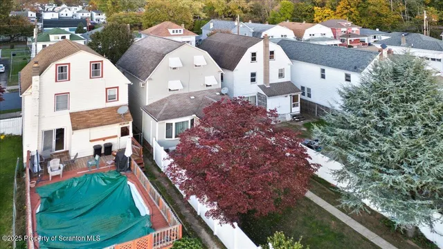 an aerial view of a house with garden space and swimming pool