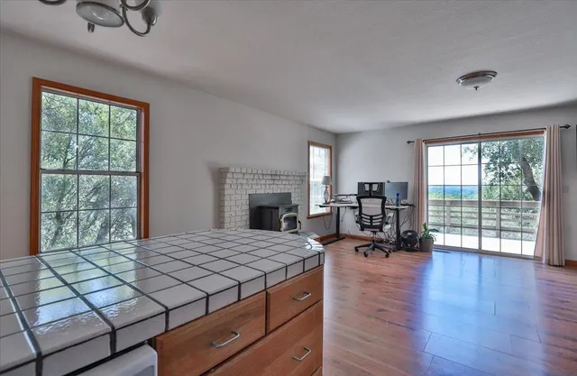 a living room with furniture large window and wooden floor
