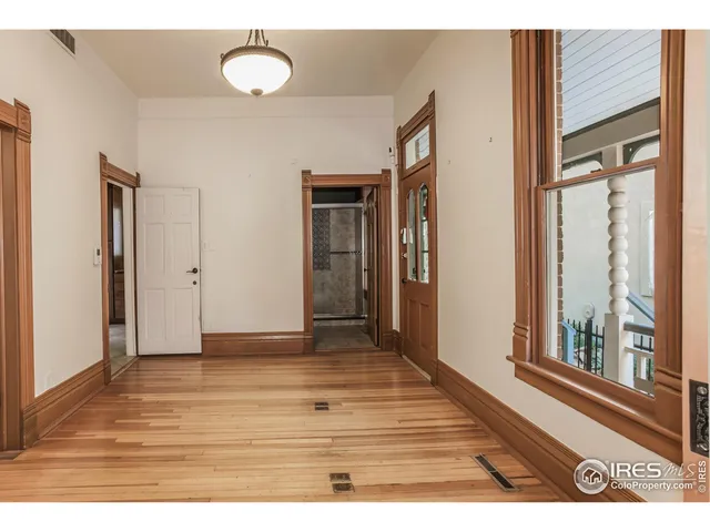 a view of a room with wooden floor and window