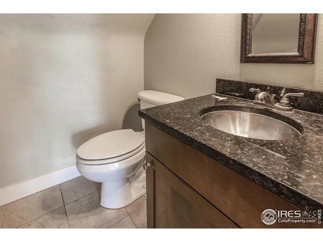 a bathroom with a granite countertop sink a toilet and a mirror