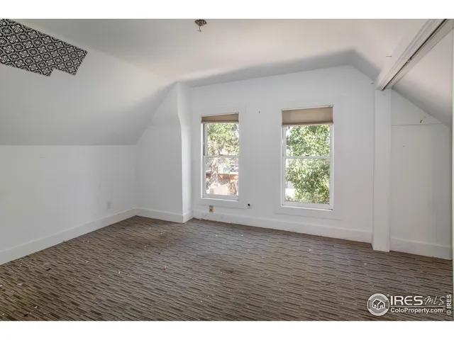 an empty room with wooden floor and window