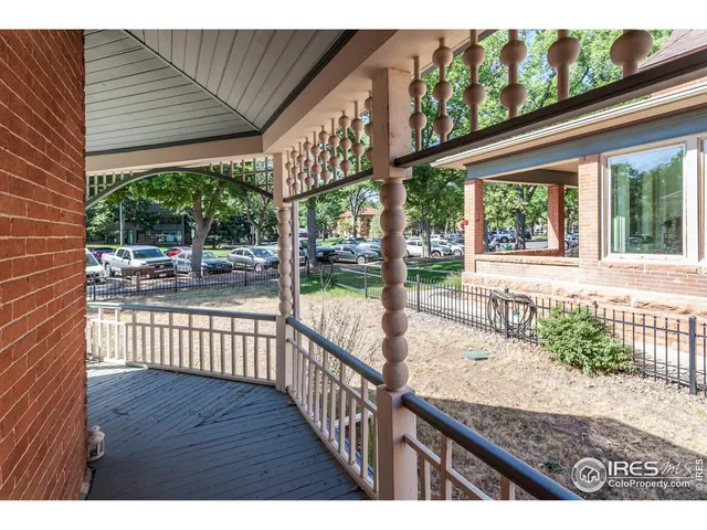 a view of a porch with wooden floor and iron stairs