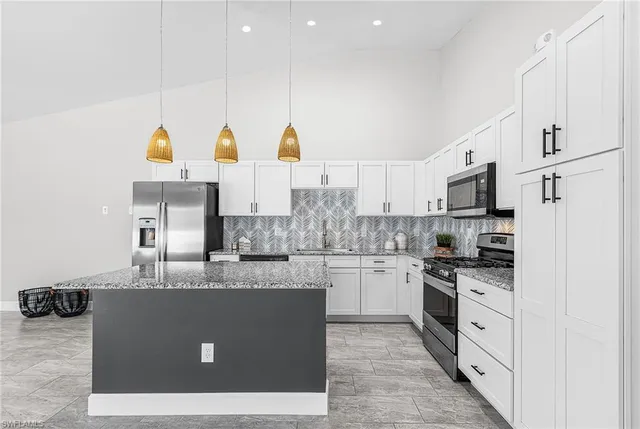 a kitchen with stainless steel appliances granite countertop a stove a sink and a refrigerator