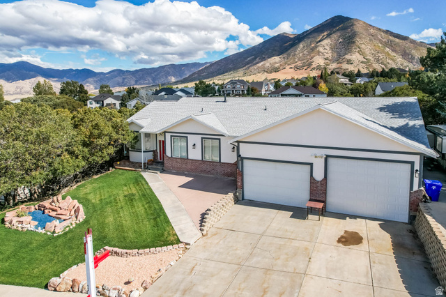 569 Elk Meadow Loop Tooele, UT 84074 - Photo 54 of 56 Single story home with brick siding, a mountain view, an attached garage, and driveway