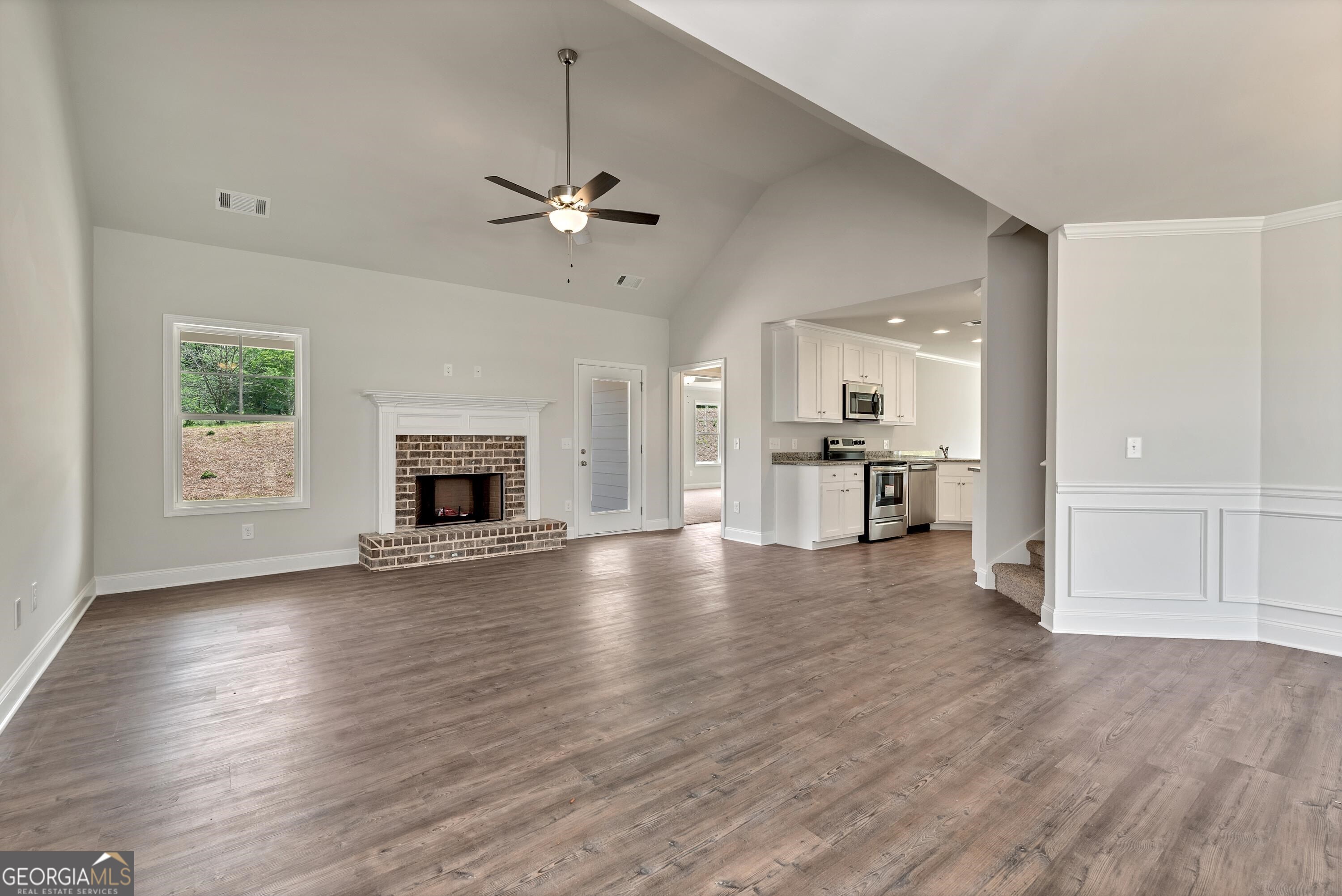 439 Equestrian Walk Winder, GA 30680 - Photo 7 of 33 an empty room with wooden floor fireplace and windows