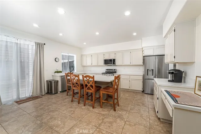 a kitchen with a dining table chairs appliances and cabinets