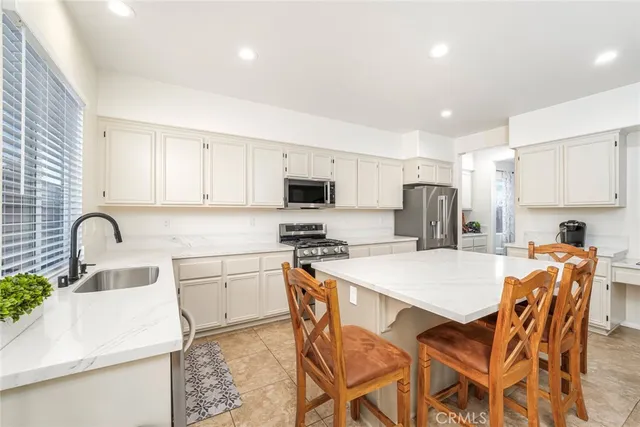 a kitchen with stainless steel appliances a stove a sink a refrigerator white cabinets and a refrigerator