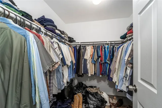 a view of walk in closet with clothes