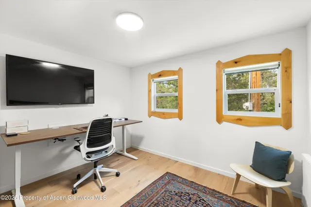 a view of a workspace with furniture and a flat screen tv