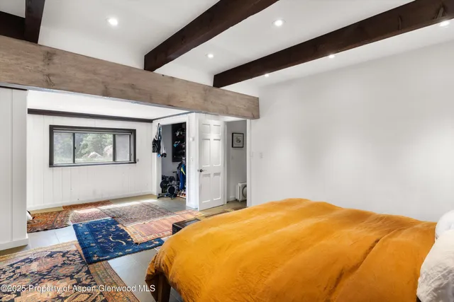a bedroom with bed and wooden floor