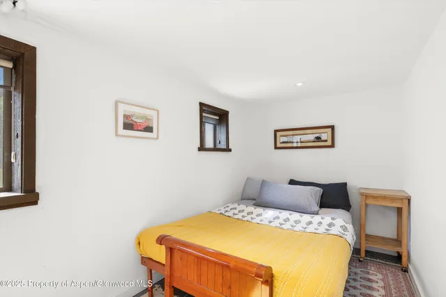 a bedroom with a bed and painting on the wall