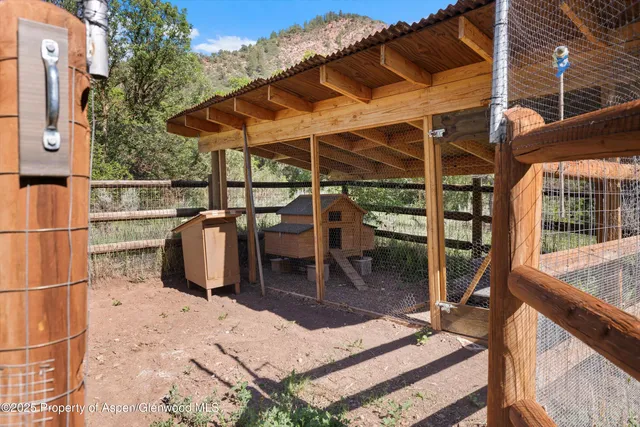 a view of a patio with table and chairs with wooden floor and fence