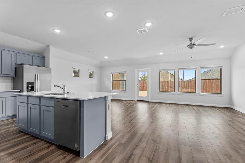 718 Parkside Drive Lavon, TX 75166 - Photo 22 of 22 Kitchen with appliances with stainless steel finishes, a kitchen island with sink, open floor plan, dark wood-style floors, and recessed lighting