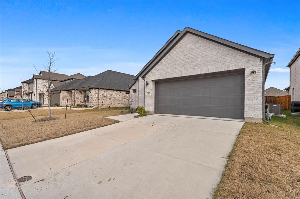 718 Parkside Drive Lavon, TX 75166 - Photo 3 of 22 View of front of home with concrete driveway, a front yard, and brick siding