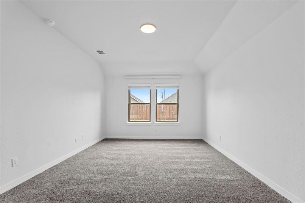 718 Parkside Drive Lavon, TX 75166 - Photo 9 of 22 Carpeted empty room with baseboards and vaulted ceiling